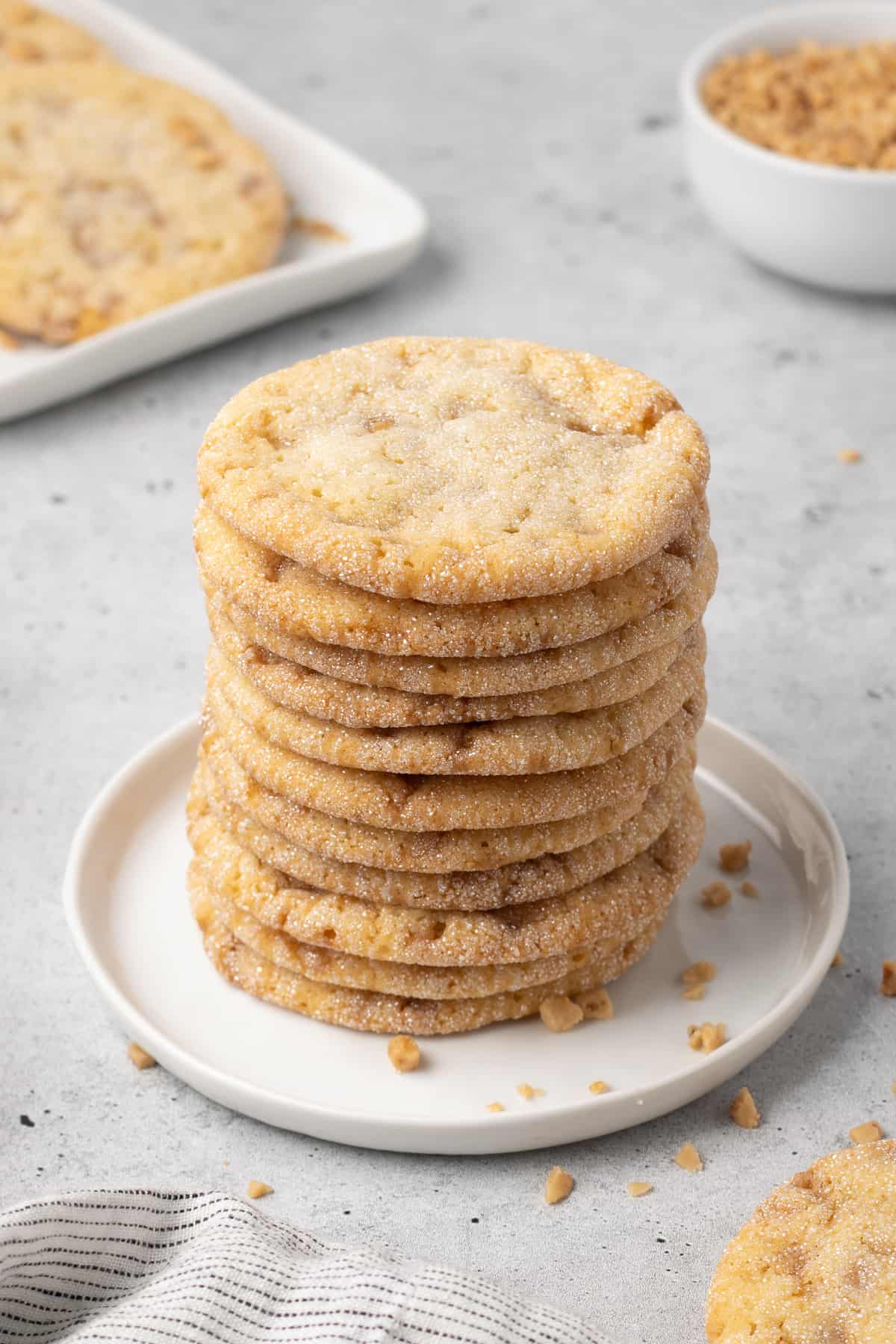 A tall stack of toffee cookies on a small white plate.