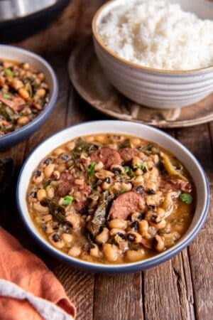 Two bowls of black eyed peas in front of a bowl of white rice.