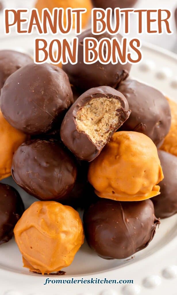 A close up of a chocolate coated bon bon with a bite missing on top of a stack with text.