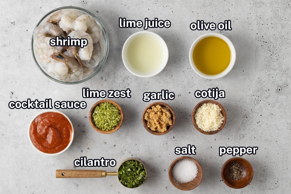 Raw shrimp and other ingredients to make shrimp skewers in small bowls with text.