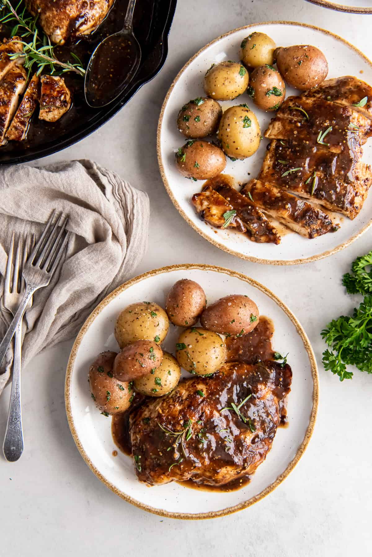 A top down shot of two dinner plates with balsamic chicken and potatoes.