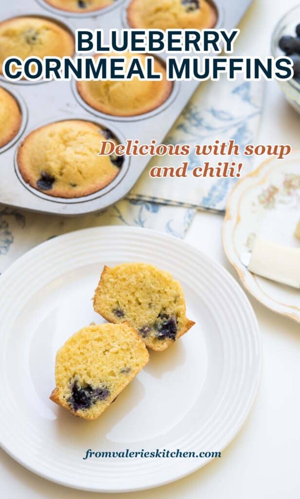 A blueberry cornmeal muffin sliced in half on a white plate next to a muffin tin with text.