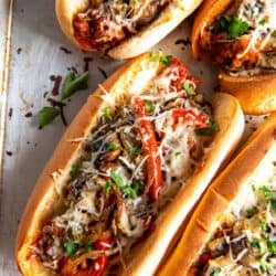 A top down shot of four Italian Sausage Sandwiches on a baking sheet.