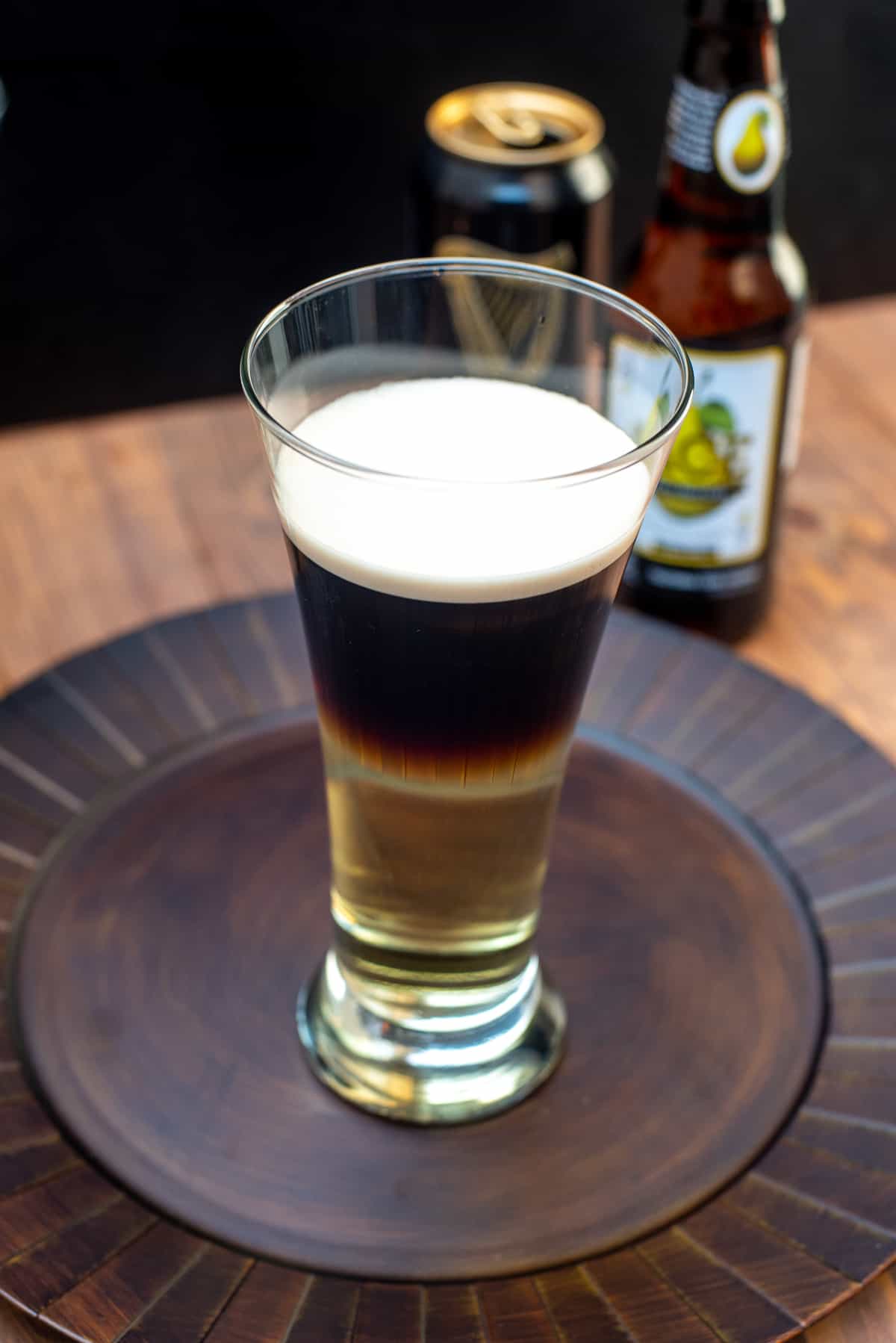A half Guinness half cider Snakebite Drink on a brown platter.