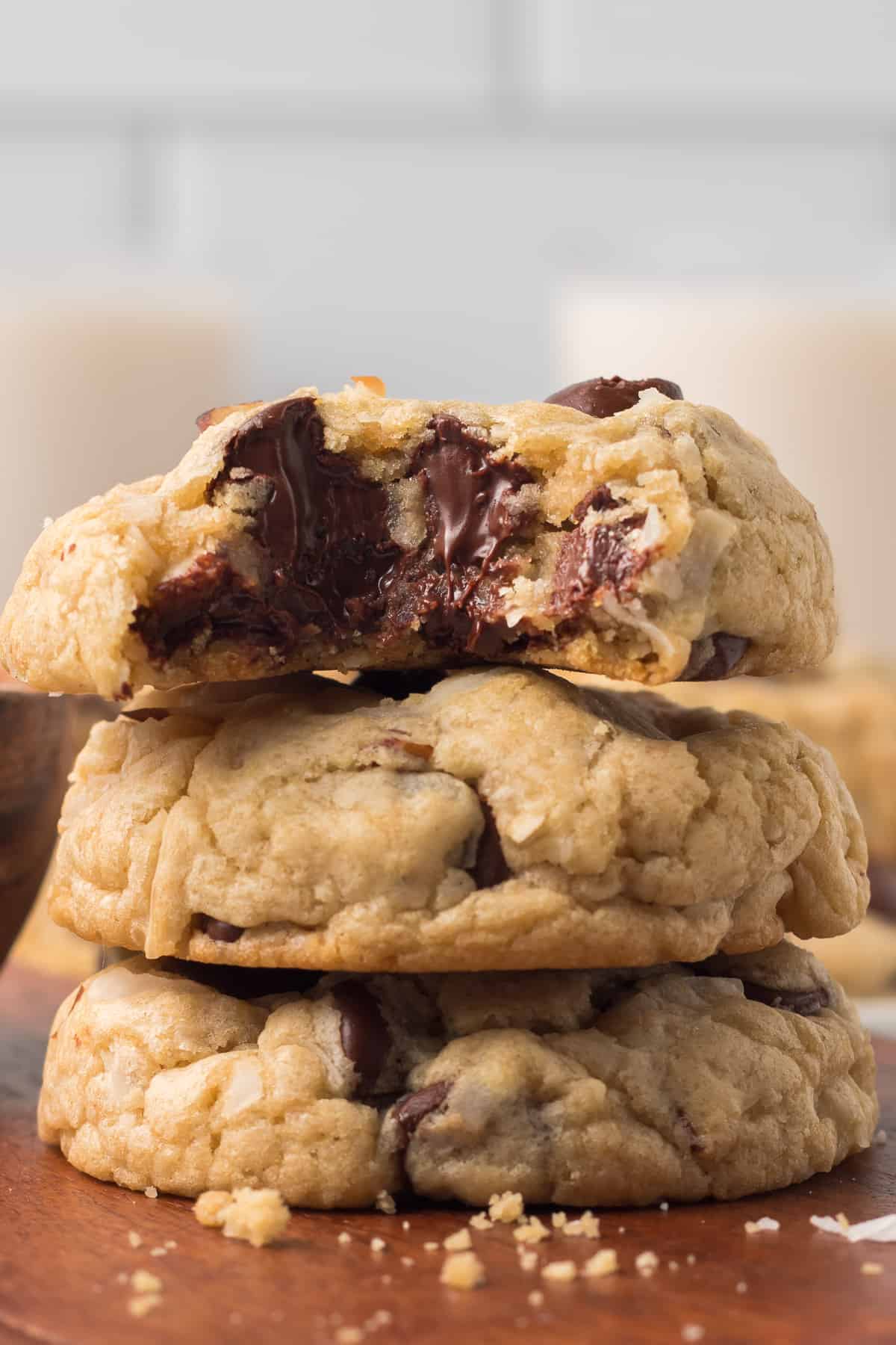 A stack of three cookies with a bite missing from the one on top.