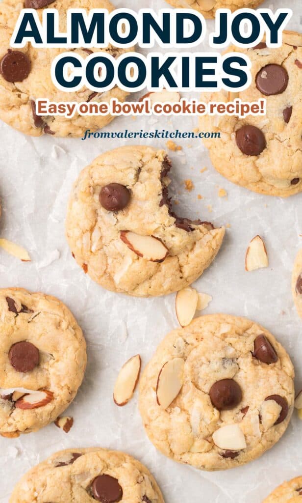 A top down shot of almond joy cookies on parchment paper with a bite missing from one of them with overlay text.