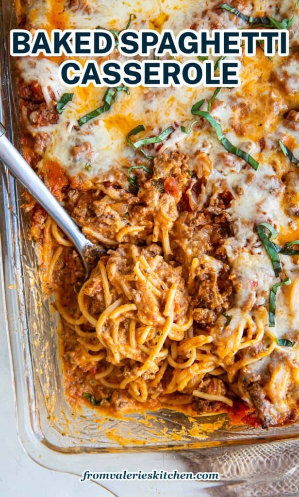 A top down shot of a spoon resting in a casserole dish full of spaghetti with text.