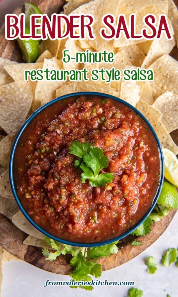 A top down shot of salsa in a bowl on a wood platter with tortilla chips with text.