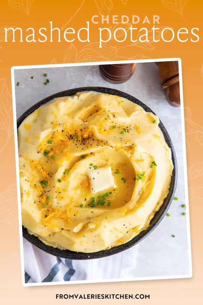 A bowl filled with cheddar mashed potatoes with text overlay.
