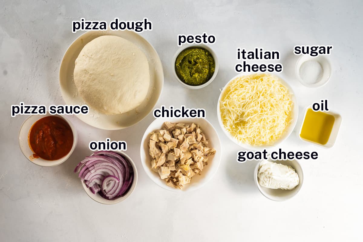 Pizza dough, sauce, chicken, pesto and other ingredients in bowls with text.