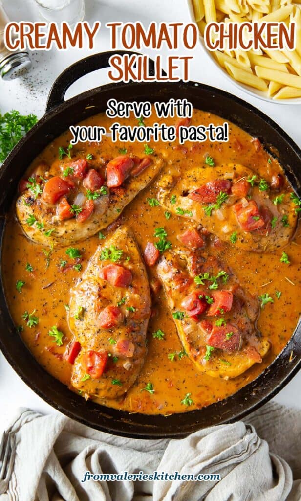 A top down shot of chicken in a tomato cream sauce in a cast iron skillet with text.