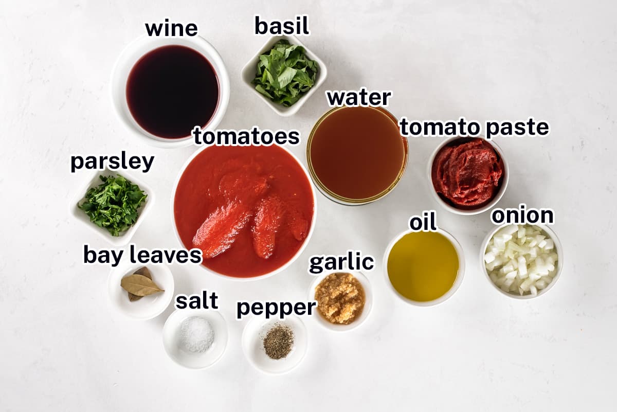 Canned tomatoes, red wine and other ingredients for homemade Italian tomato sauce.