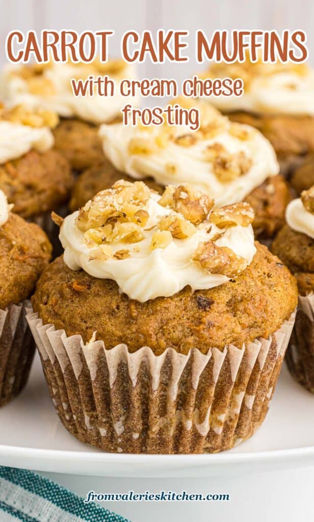 Carrot cake muffins on a white plate topped with cream cheese frosting and chopped walnuts with text.