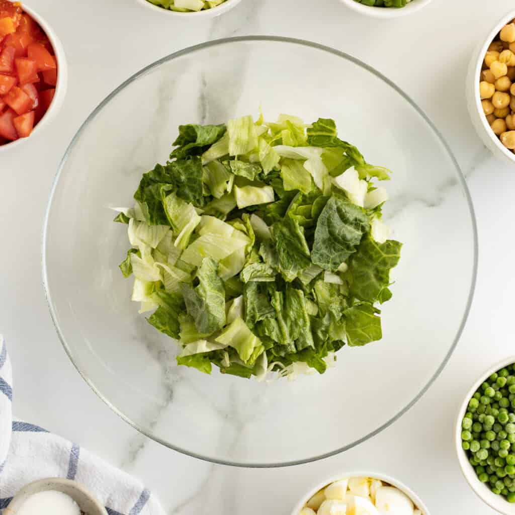 A layer of lettuce in a glass bowl.
