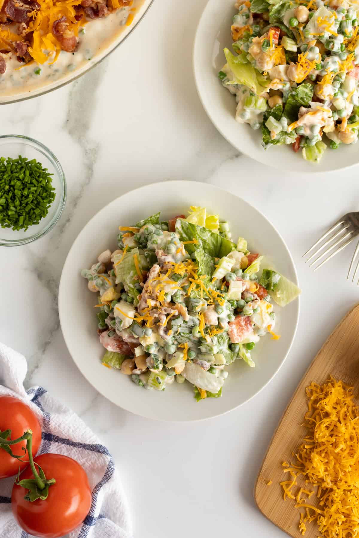 A top down shot of a serving of salad with creamy dressing on a two plates.