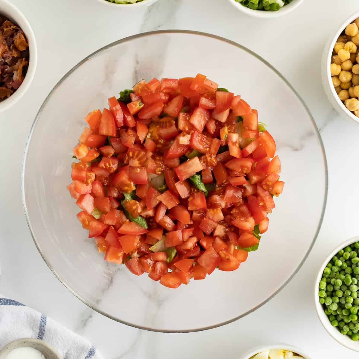 A layer of chopped tomatoes in a glass bowl.