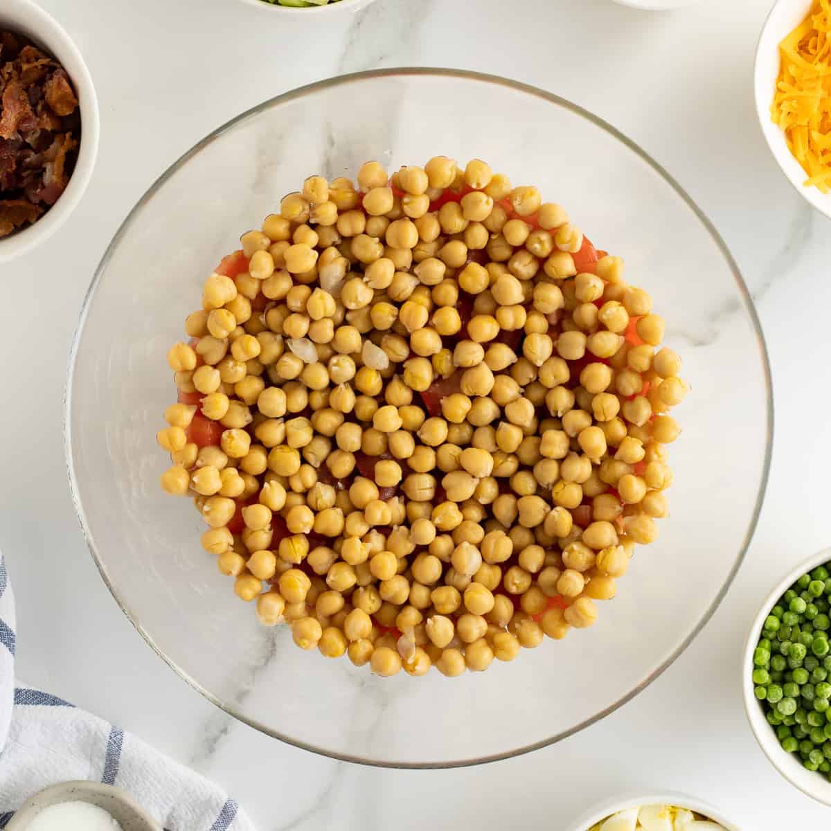 A layer of garbanzo beans in a glass bowl.