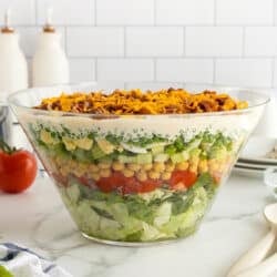 A layered salad in a glass bowl.