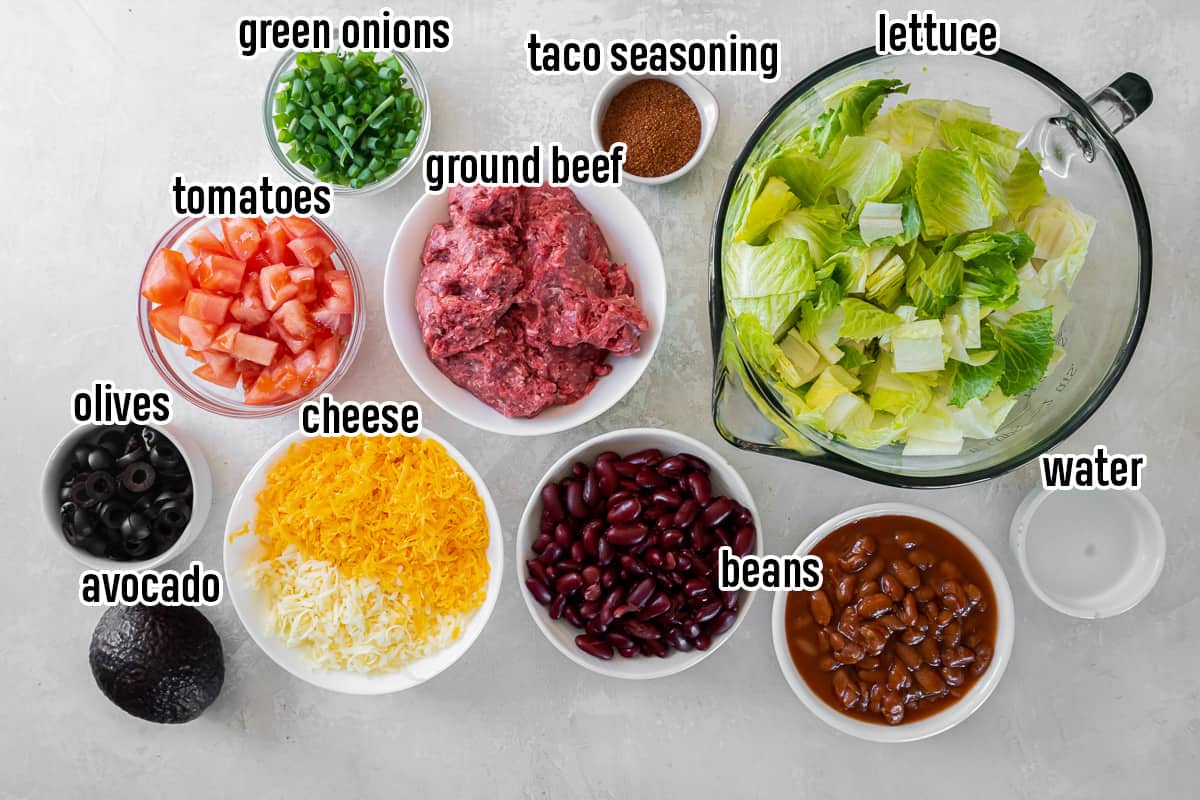 Lettuce, ground beef, cheese, and other ingredients for Taco Salad with text.