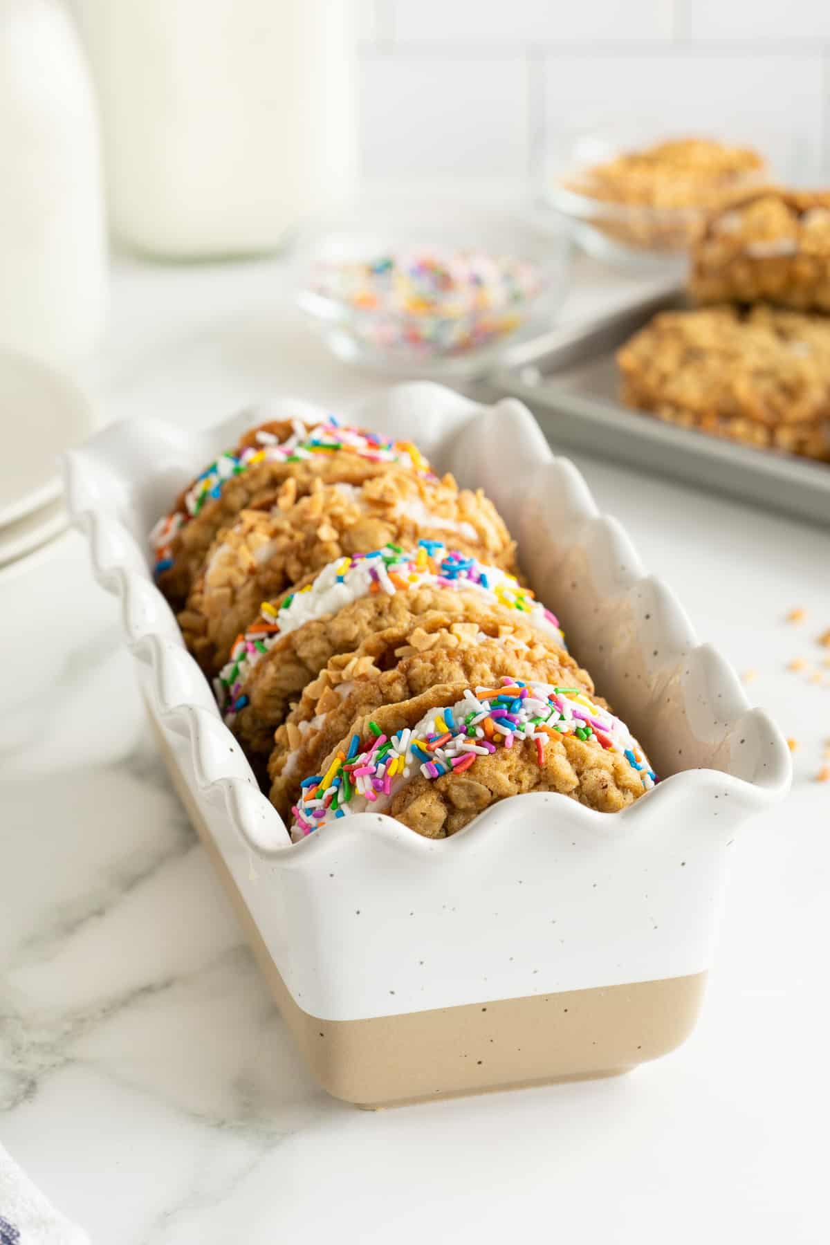 A side view of cookie ice cream sandwiches in a ceramic loaf pan.