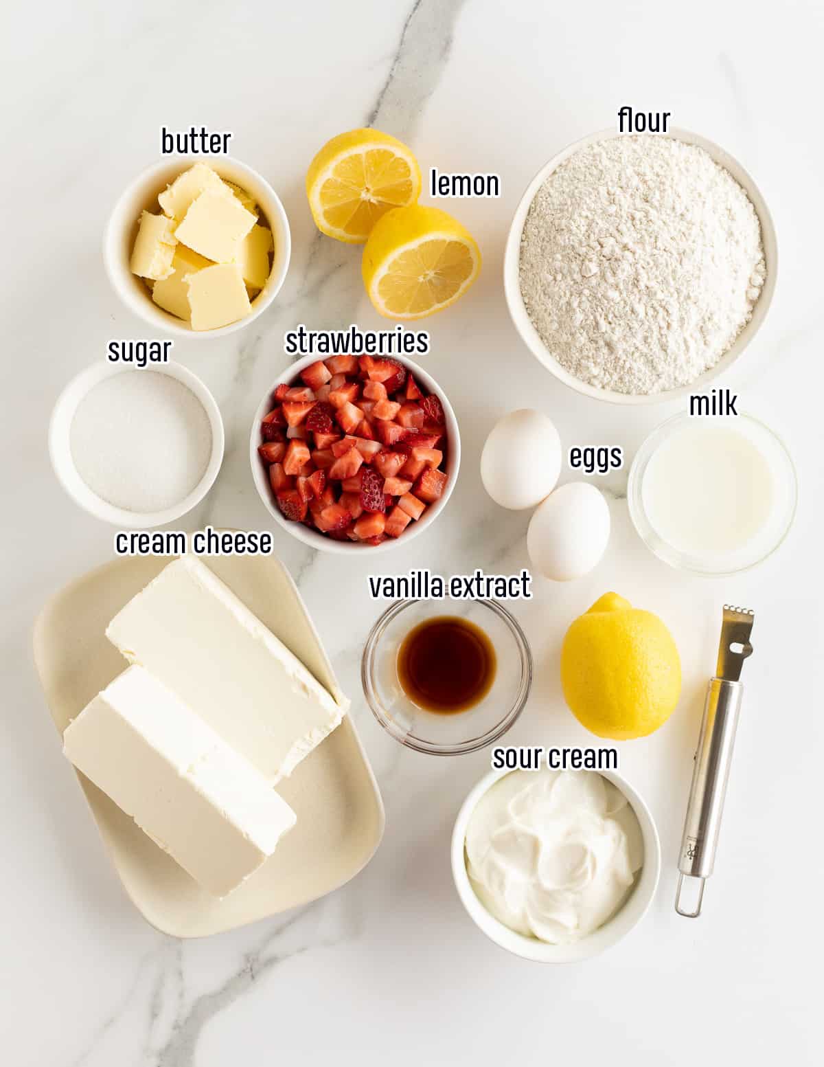 Strawberries, cream cheese, lemon and other ingredients in bowls with text.
