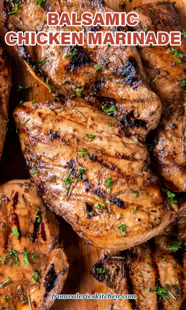 A top down close up shot of grilled chicken breasts with text.