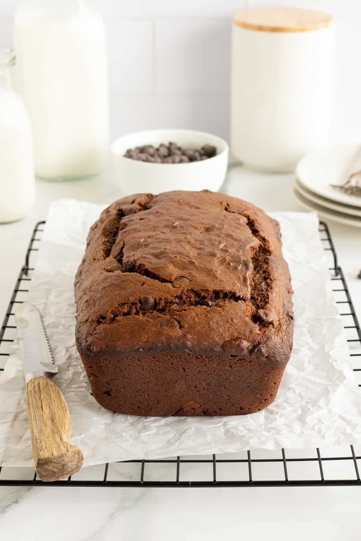 A loaf of chocolate peanut butter banana cooling on a wire rack on a kitchen counter.