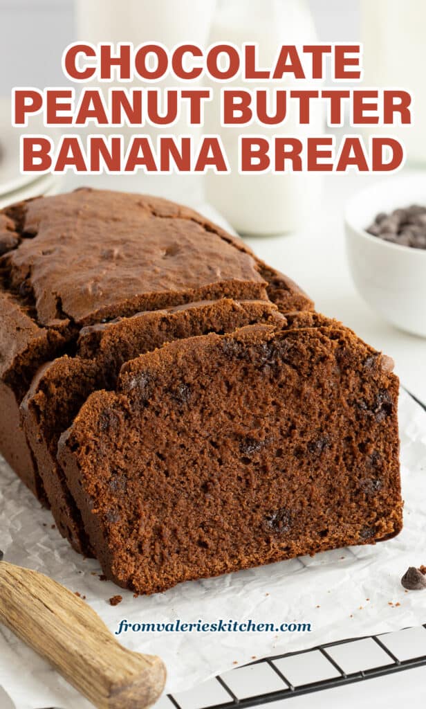A side view of a sliced loaf of chocolate peanut butter banana bread on a wire rack with a serrated knife with text.
