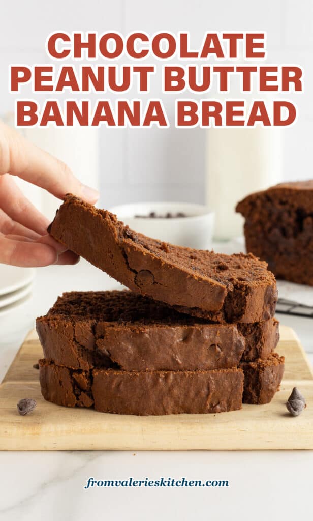 A hand lifting a slice of chocolate peanut butter banana bread from a stack of slices on a wood cutting board with text.