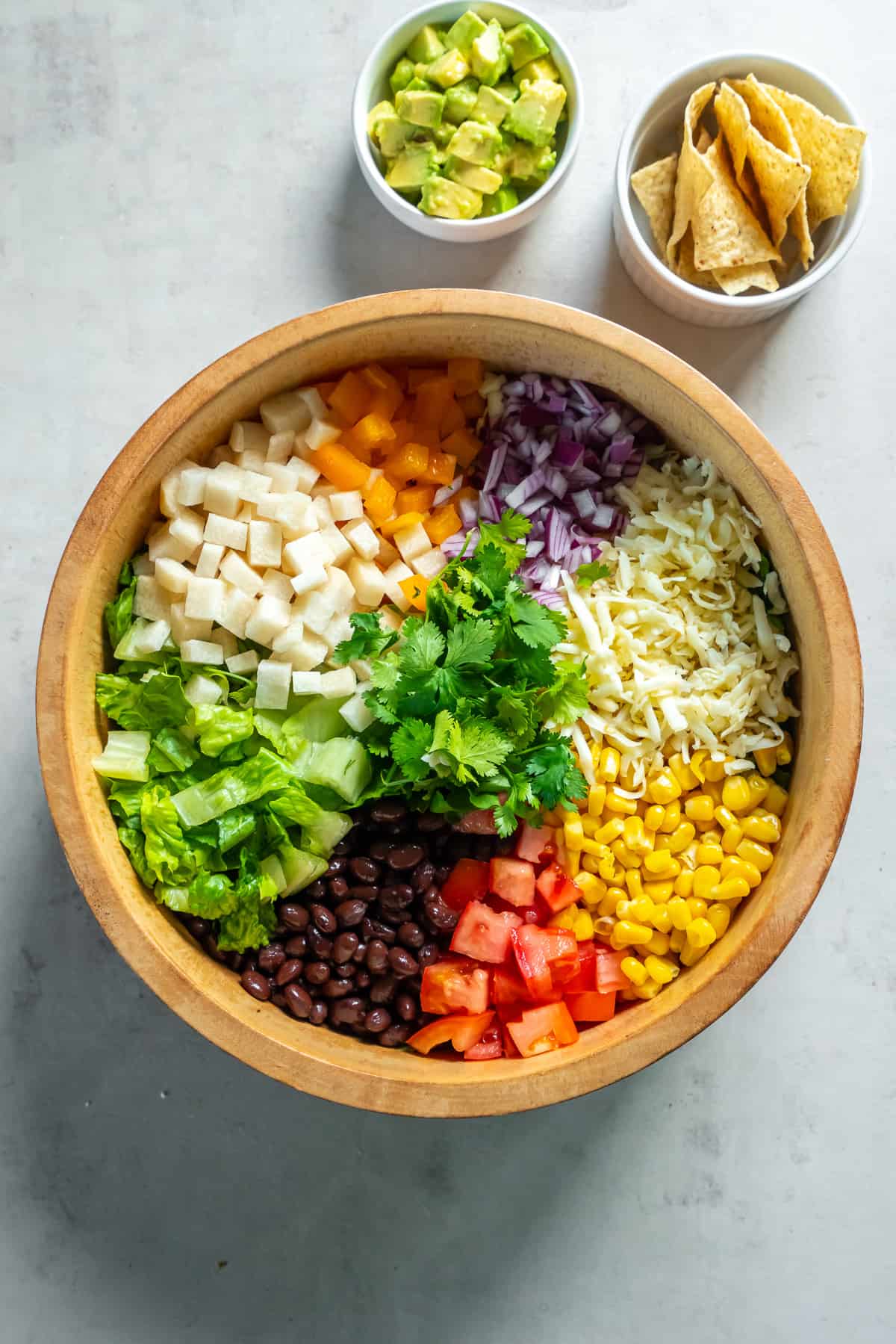 Southwest Chopped Salad ingredients in neat rows in a wood salad bowl.
