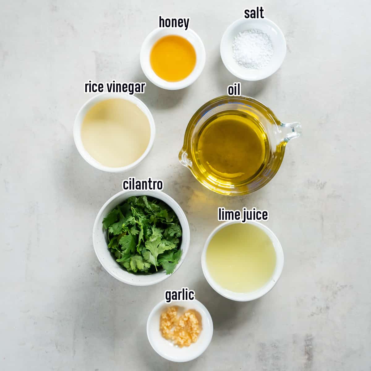 Cilantro, lime juice, oil and other ingredients for cilantro lime vinaigrette with text.