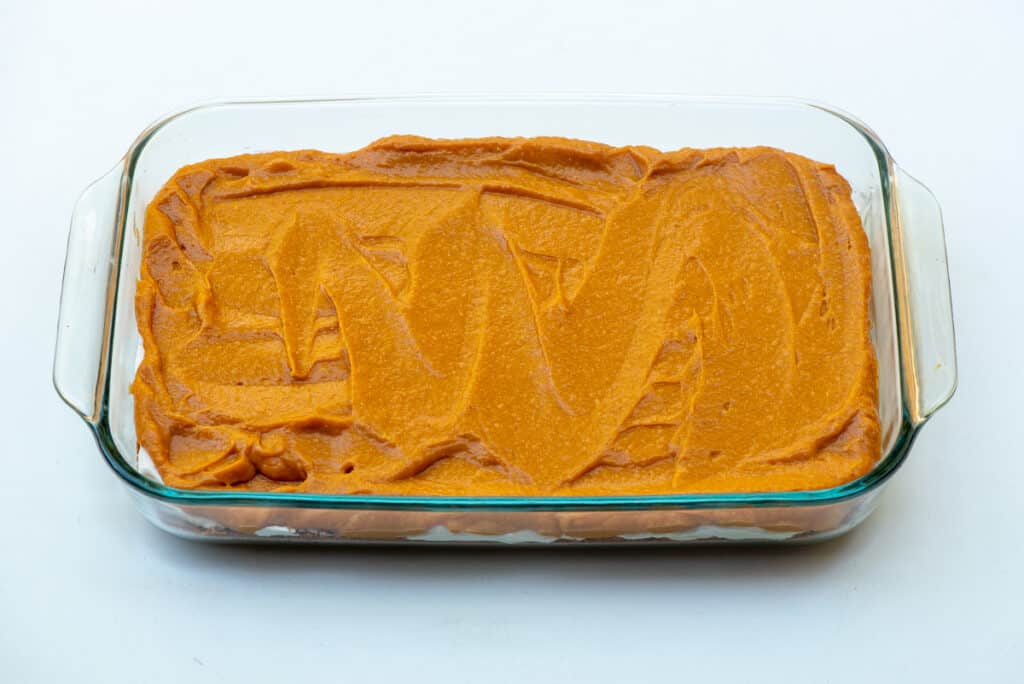 A pumpkin mixture layered in a glass baking dish.