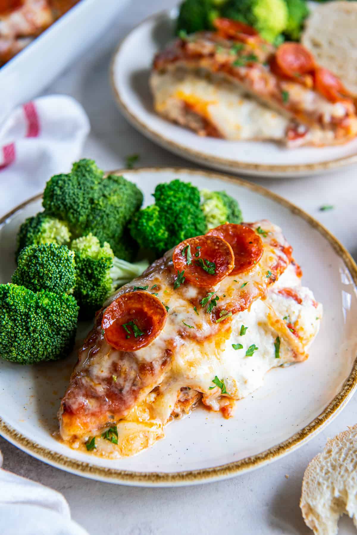 A slice of Pizza Chicken on a white plate with broccoli.