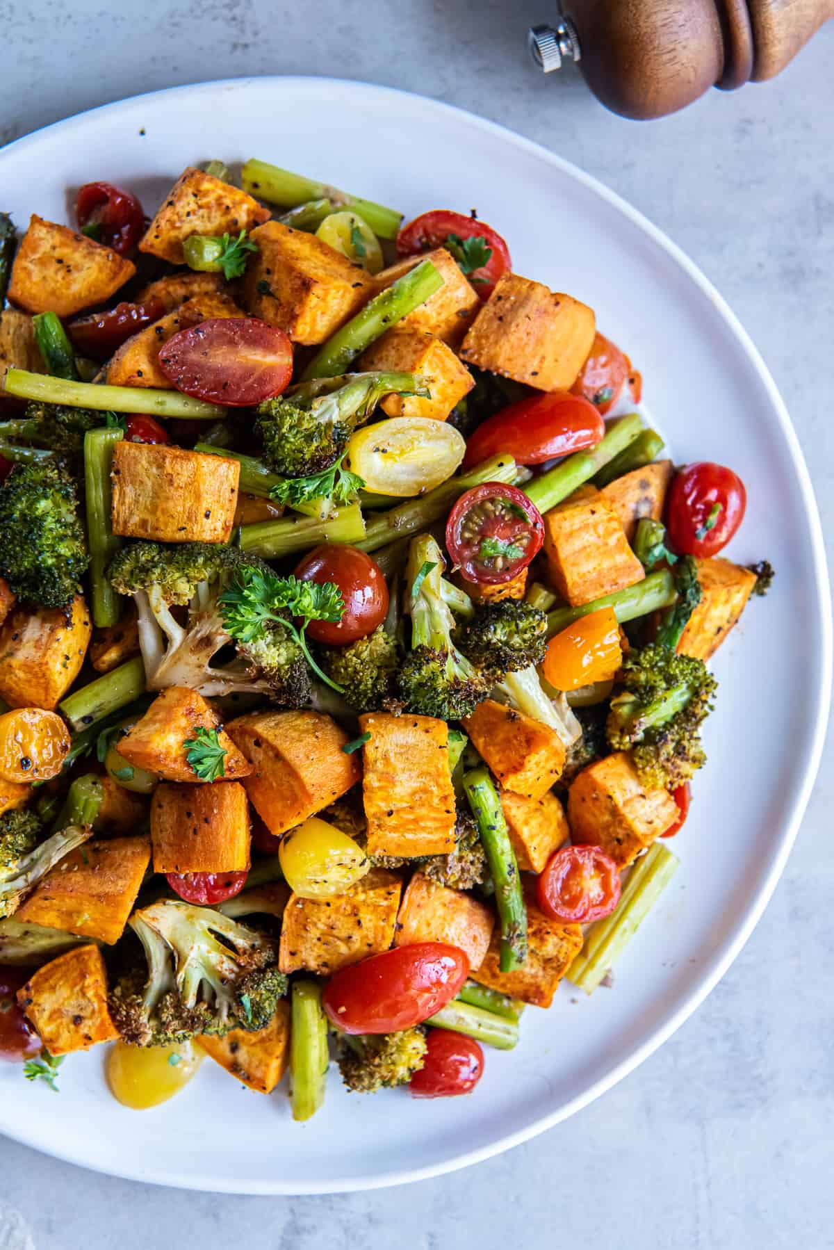 A top down shot of roasted vegetables on a white plate.