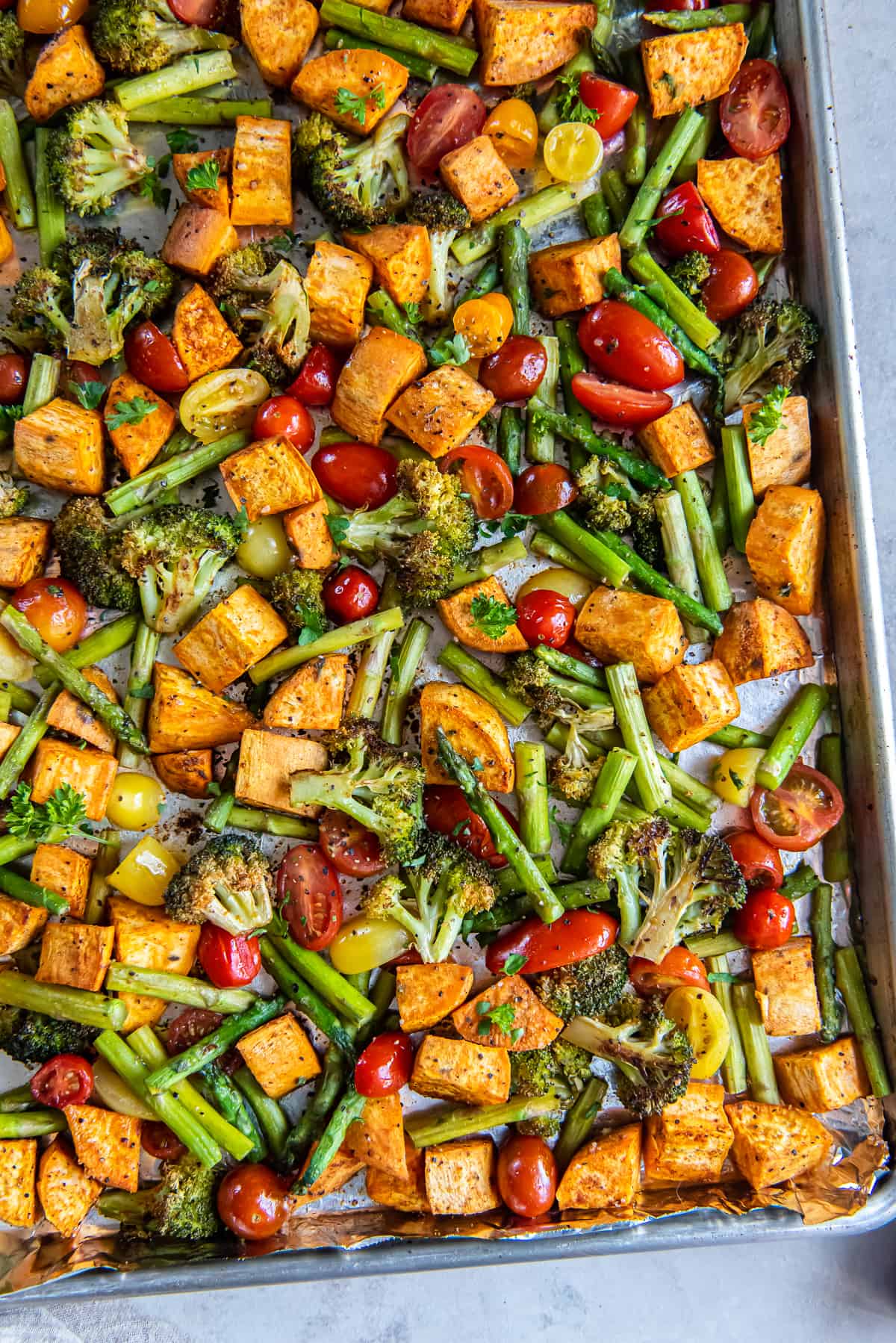 A top down shot of roasted vegetables on a sheet pan.