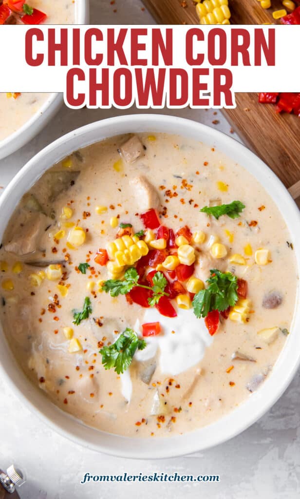 A top down shot of a white bowl filled with chowder with chicken and corn topped with sour cream and diced bell peppers with text.