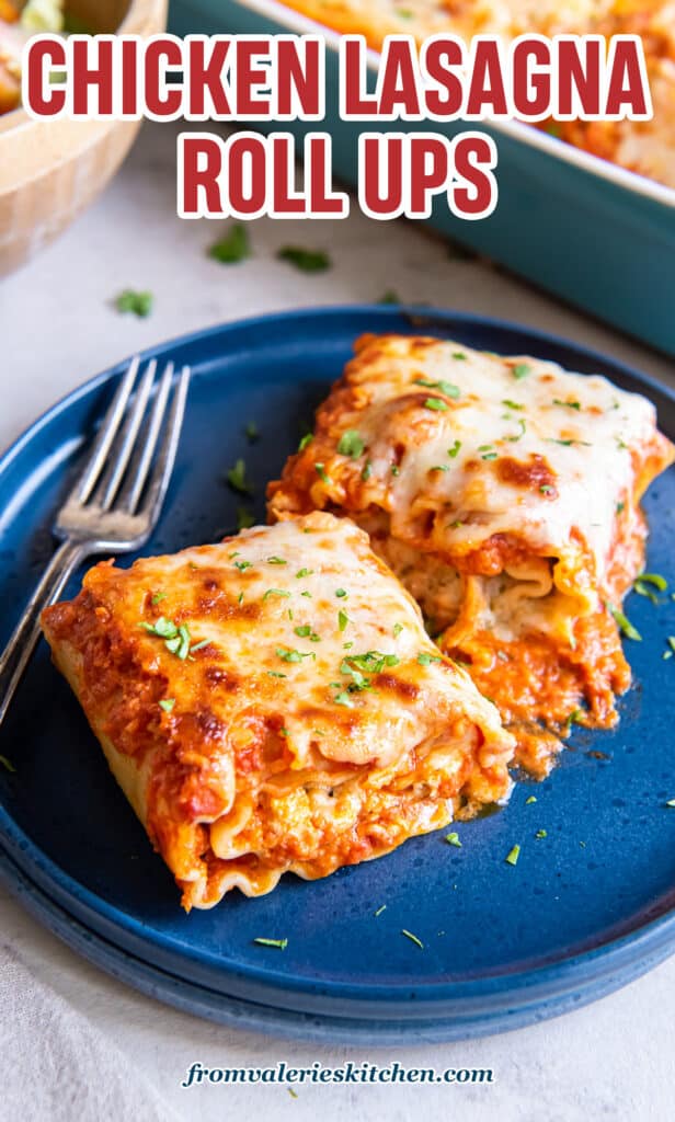 Two chicken lasagna roll ups on a blue plate with a fork with text