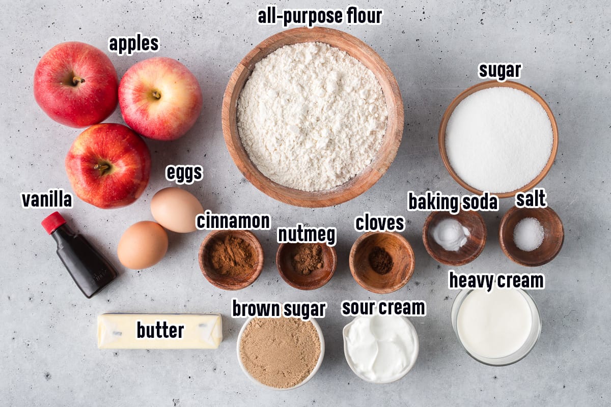 Apples, flour, sugar and other ingredients for apple cake with text.