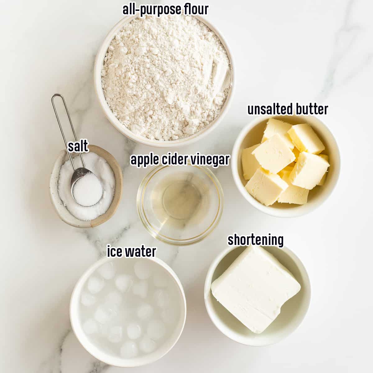 Flour, butter, shortening, apple cider vinegar, salt, and ice water in bowls with text.