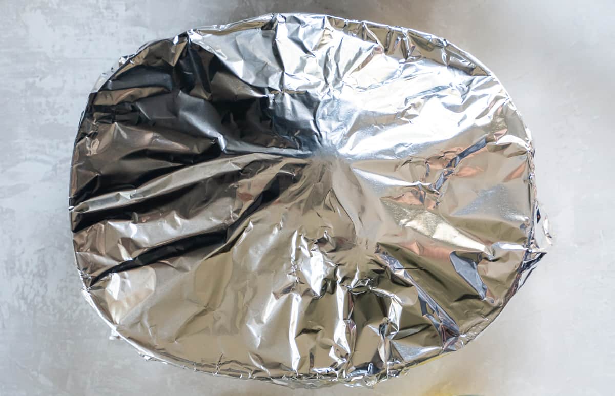 A top down shot of a baking dish covered with aluminum foil.