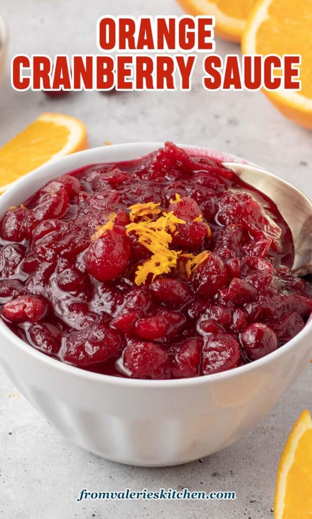 A small mason jar filled with cranberry sauce and topped with orange zest with text.