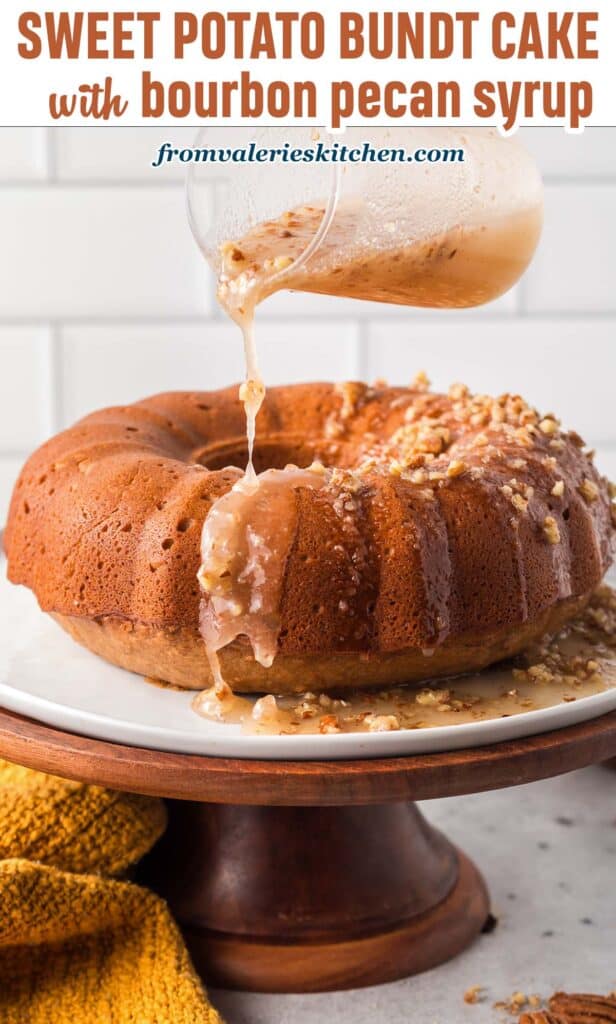 Bourbon pecan icing pour over a Bundt cake on a wooden cake pedestal with text.