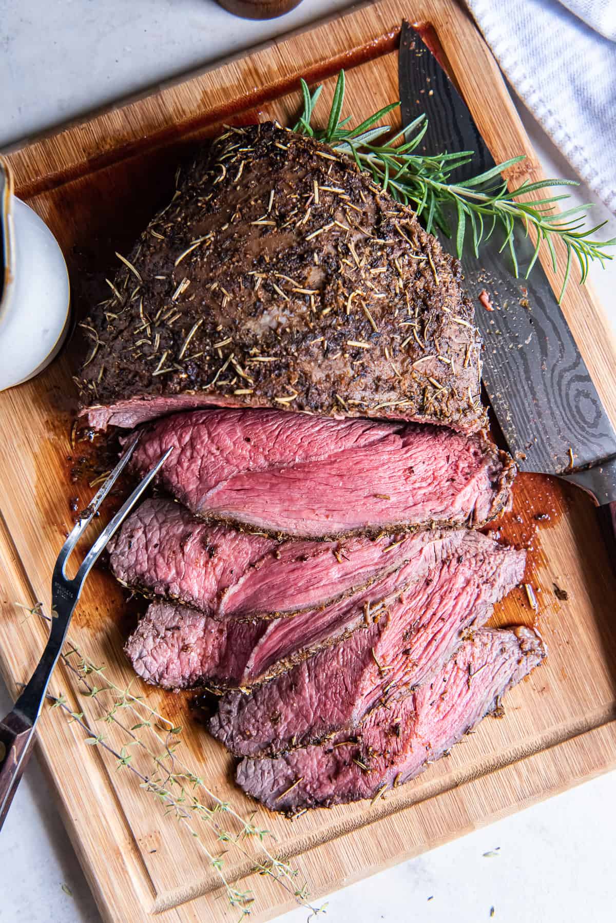 A top down shot of a sliced cross rib roast on a cutting board.