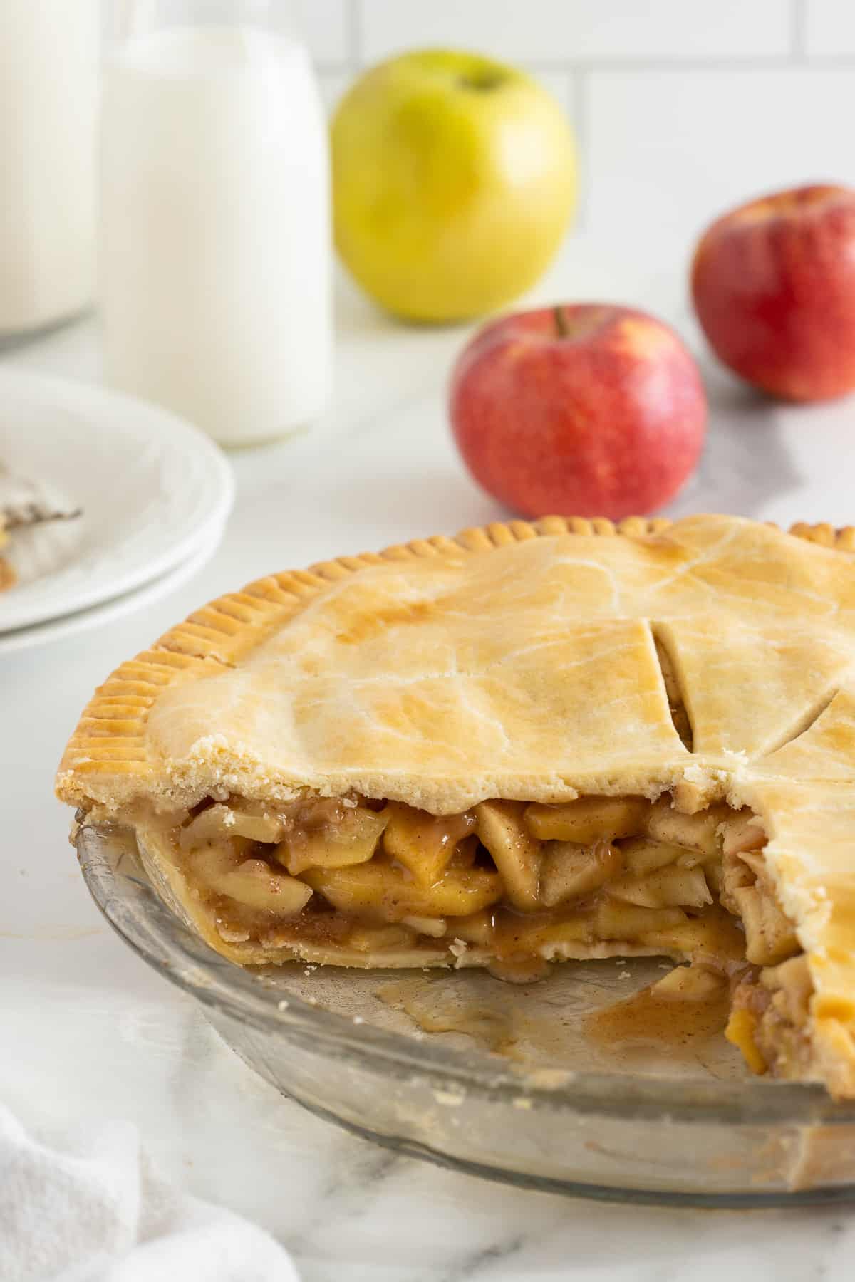 A side view of a sliced apple pie revealing the apple pie filling.