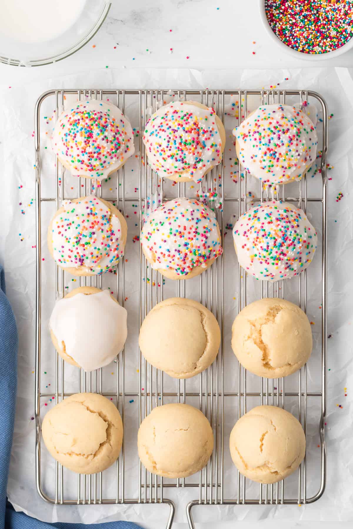Italian Cookies on a wire rack, some with icing and sprinkles and some plain.