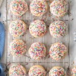 A top down shot of Italian Cookies with icing and rainbow sprinkles on a wire rack.