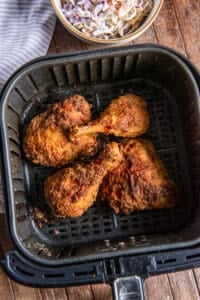 A top down shot of air fried chicken in an air fryer basket.