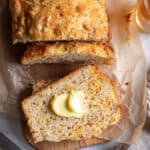 A top down shot of a buttered sliced of cheese beer bread.