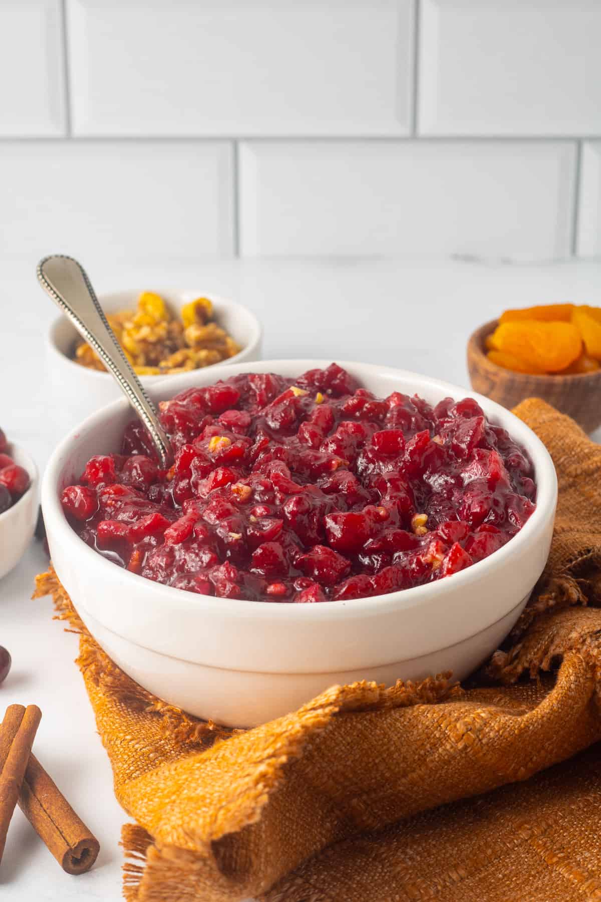 A bowl of cranberry apricot chutney on a kitchen counter.