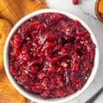 A top down shot of cranberry apricot chutney next to a gold kitchen cloth.